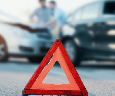 Red warning triangle in front of a car accident.