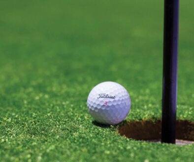 golf ball on the edge of the hole.