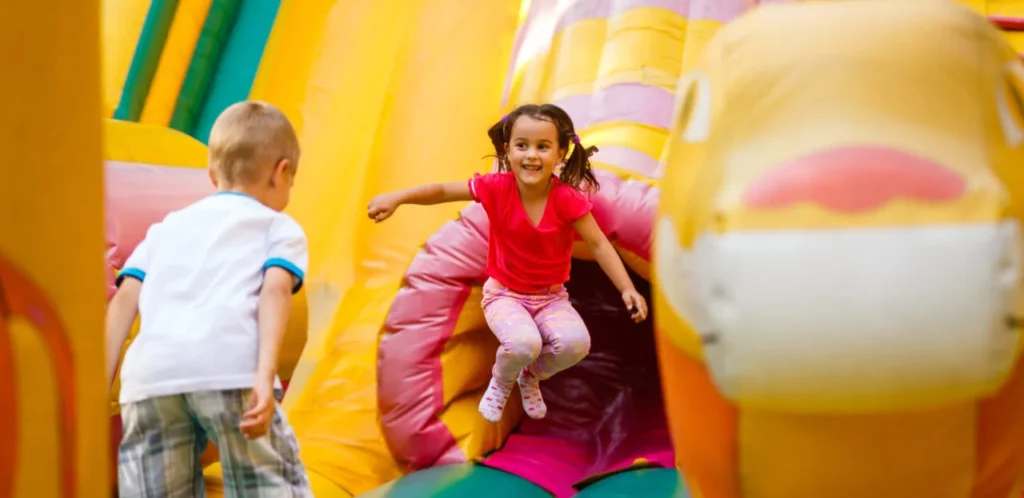 Joyful little girl playing on a trampoline.