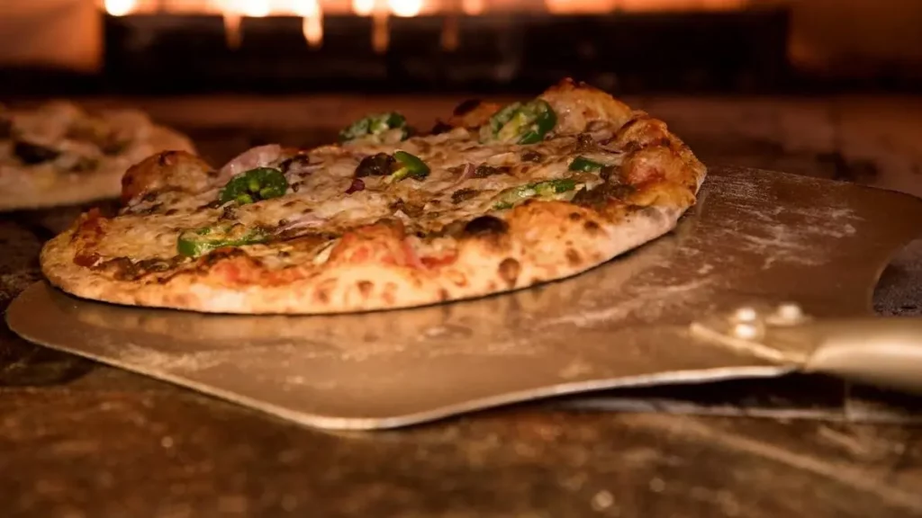 Takeaway pizza going into a pizza oven