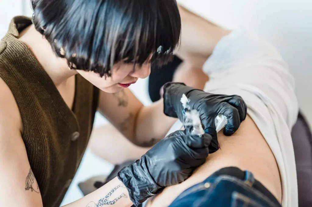 Tattoo artist doing a tattoo on a client