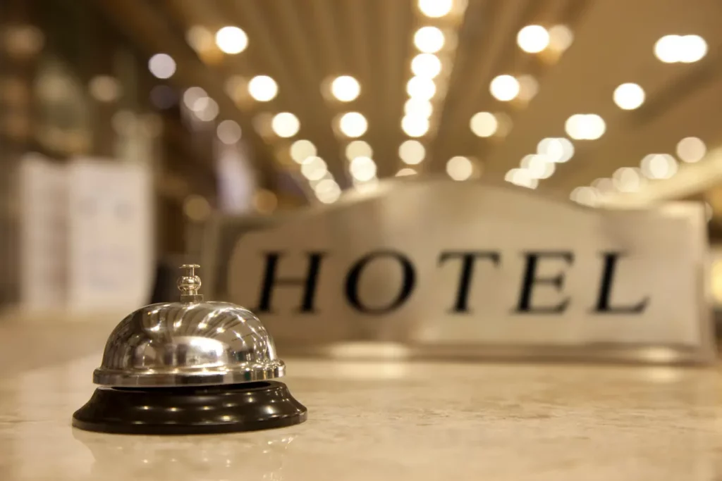 Hotel reception desk with bell and hotel sign in the background